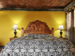 Mineral de PozosPosada Casa del Minero的一间卧室配有一张大床和两盏灯