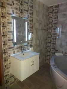 西格伏沙尔克甜蜜生活家庭旅馆的一间带水槽、浴缸和镜子的浴室