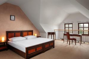 阿德尔什帕赫亚沃尔酒店的一间带一张床和一张书桌的卧室以及一个阳台