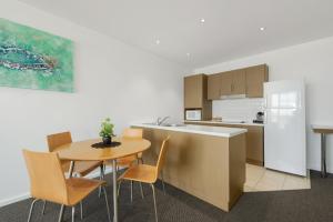 沃拉鲁Wallaroo Marina Sea Vu Apartment的厨房以及带桌椅的用餐室。