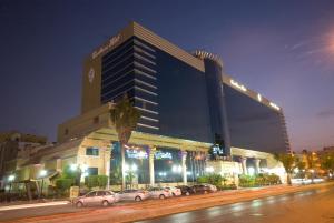 吉达吉达卡萨布兰卡酒店的一座大型建筑,前面有汽车停放