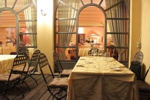 瓦雷泽科洛纳酒店的一间带桌椅和镜子的用餐室