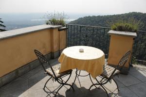 瓦雷泽科洛纳酒店的阳台配有一张桌子和两把椅子