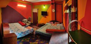 KāhārpāraDekapara Airport Guest House的一间设有两张床和椅子的房间