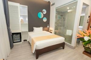 绥和市La Casa Tuy Hòa的一间卧室设有一张床和一个玻璃淋浴间