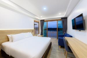 清刊Chiangkhan River Walk Hotel的一间卧室配有一张床、一张书桌和一台电视