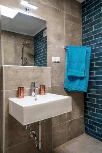 内亚卡瓦里Dimitra Beach Apartments - Nea Karvali Kavala的浴室设有白色水槽和蓝色毛巾。