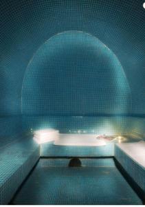 沃伊内亚萨Zan Hotel的蓝色瓷砖浴室设有浴缸和水槽