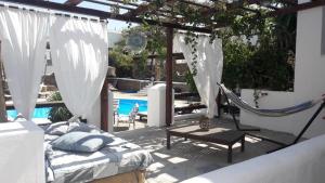 伊奥斯乔拉地中海酒店的一个带吊床和床的庭院,庭院内设有游泳池