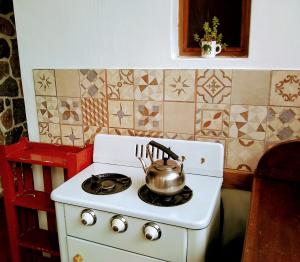 德尔迪克镇Casita de Piedra B&B的厨房内的炉灶上方的茶壶