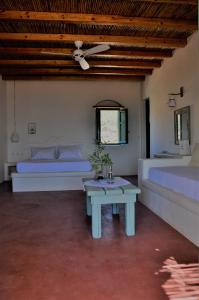 考弗尼西亚Pambelos Lodge的一间卧室配有两张床、一张桌子和一张床