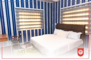 阿克拉Covenant Hotel的一间卧室配有一张床和蓝白色条纹墙