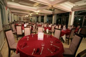 马拉喀什帝豪假日Spa酒店的宴会厅配有红色桌椅和酒杯