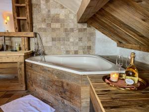 莱斯奥琉斯Charming chalet, 3 rooms, 6 to 8 persons, Meribel, Les Allues的带浴缸和一瓶香槟的浴室