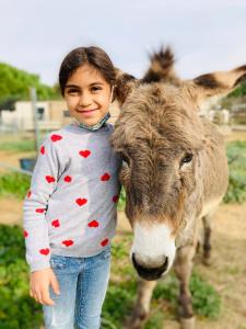 PonteillaASINERIE KULENI的站在一头奶牛旁边的一个小女孩