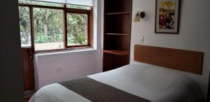 基多波萨达德尔梅柏旅馆的卧室配有白色的床和窗户。