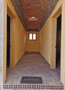 Mineral de PozosPosada Casa del Minero的一条空的走廊,铺着瓷砖地板,设有天花板
