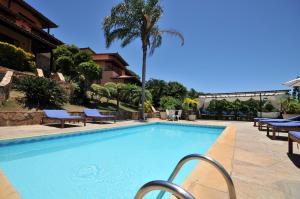 布希奥斯Aguabúzios Hotel的一个带椅子的大型游泳池,一个度假村