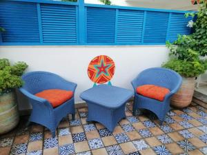 开罗Almadiafa - المضيفه的两把蓝色椅子和橙色靠垫,坐在露台上