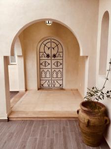 Al ḨaddādahDar ABDELKRIM的一间有门的房间,前面有植物