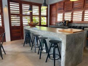 蒙达Casa Mundaú Tropical Beach Villa的厨房配有混凝土台和吧台凳