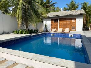 蒙达Casa Mundaú Tropical Beach Villa的一个带椅子的游泳池以及一座房子