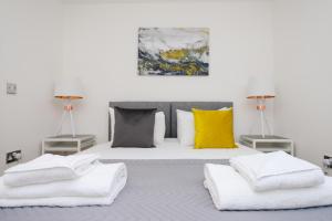 诺丁汉The Zone - Vibrant City Centre Apartment的一间卧室配有带白色床单和黄色枕头的床。
