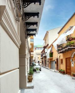 蒙雷亚莱Palazzo al Carmine的镇上的小巷,街上有车辆停放