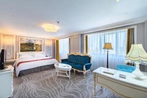 天津天津金泽大酒店的酒店客房配有一张特大号床和一张蓝色椅子