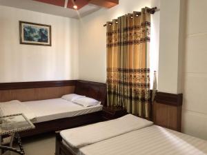 芹苴Hong Dao Hotel的客房设有两张床和窗户。