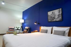 曼谷The View Residence的一间卧室设有一张蓝色墙壁的大床
