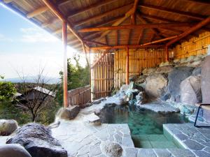 FutoWe Home Villa ～城ケ崎温泉～的一座带木屋顶的建筑里的一个水池