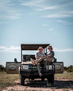 曼耶雷蒂野生动物园Honeyguide Tented Safari Camp - Khoka Moya的两个人坐在吉普车后面