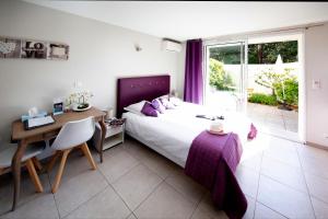 戛纳Villa Etoile Cannes的卧室配有1张床、1张书桌和1张桌子及椅子