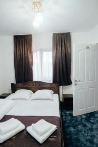 舒加塔格盐矿镇Casa Daiana的一间卧室设有两张带白色床单的床和窗户。