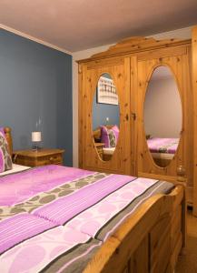 巴特司塔福斯坦Ferienwohnung in Bad Staffelstein OT Grundfeld的一间卧室配有一张木床和木柜