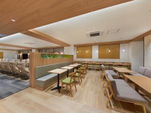 东京Smart Stay SHIZUKU Shinagawa-Oimachi的用餐室配有木桌和椅子