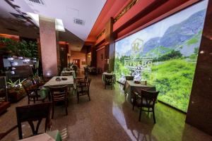 巴亚马雷瑞瓦鲁斯酒店的餐厅设有桌椅和大窗户。