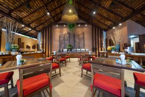 沙美岛奥普劳度假酒店的餐厅设有木桌和红色椅子