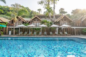 沙美岛奥普劳度假酒店的度假村的游泳池,配有椅子和遮阳伞