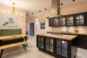 萨格勒布Apartment A.B.S. Secret Oasis的厨房配有黑色橱柜和木桌