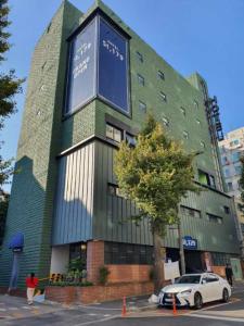 仁川市St. 179 Incheon Hotel的前面有停车位的建筑