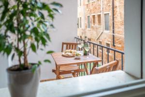 威尼斯Ca del Mar Venice Luxury Apartments的阳台上的桌子上放着一篮子的食物和酒杯