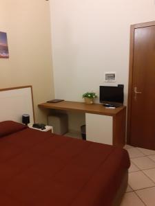 莱魁勒Tenuta Caradonna的一间卧室配有一张桌子、一台电脑和一张床