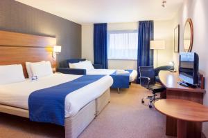 布伦特里希尔顿布伦特里汉普顿酒店的酒店客房设有两张床、一张桌子和一台电视。