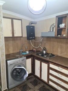 博尔若米Guest House Nua的厨房配有洗衣机和水槽