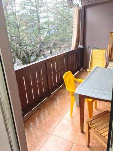 博尔若米Guest House Nua的阳台配有桌椅和窗户。