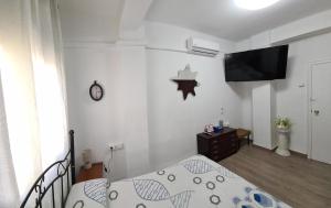 瓦伦西亚Habitación San Cayetano的一间卧室配有一张床,并在一间客房内配有电视。