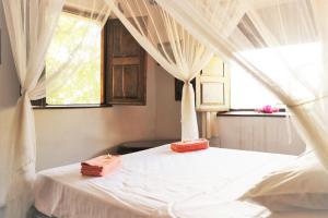 IboMiti Miwiri的卧室配有白色的床、窗帘和窗户