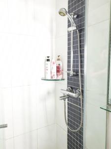 仁川市爱特尔好日子旅馆的浴室设有蓝色瓷砖墙和淋浴。